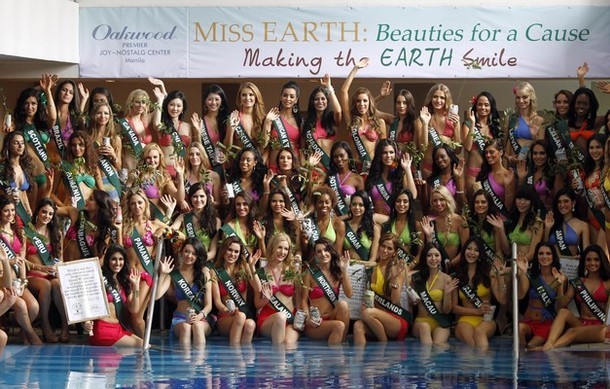 Candidates of the Miss Earth beauty contest hold tree seedlings and placards promoting environmental advocacy in Manila