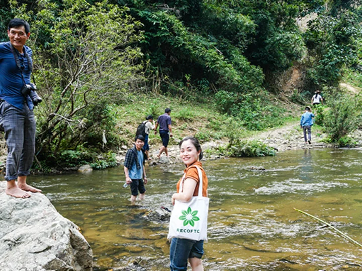 A team of representatives from Explore prepare to cross a stream en route to a proposed white basil planting site in Tam Hop, Viet Nam. 