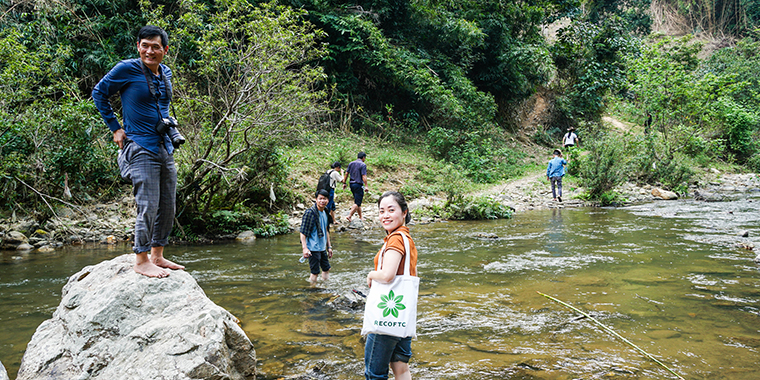 A team of representatives from Explore prepare to cross a stream en route to a proposed white basil planting site in Tam Hop, Viet Nam. 