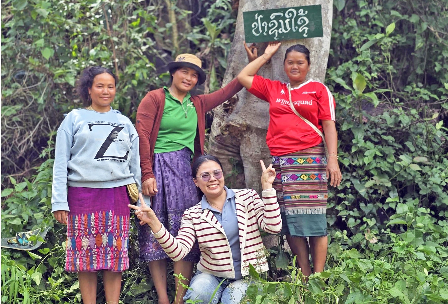 Vanhphone Siluangphet and other women from Mokhong village stand beside a forest boundary sign.