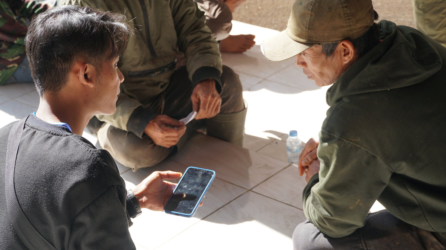 Local youth interviews a coffee farmer in Indonesia.