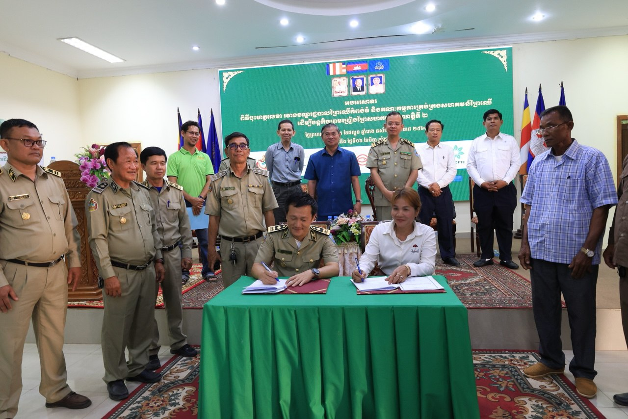 Community forestry committee chief Im Nou signs an agreement with the Forestry Administration Cantonment.