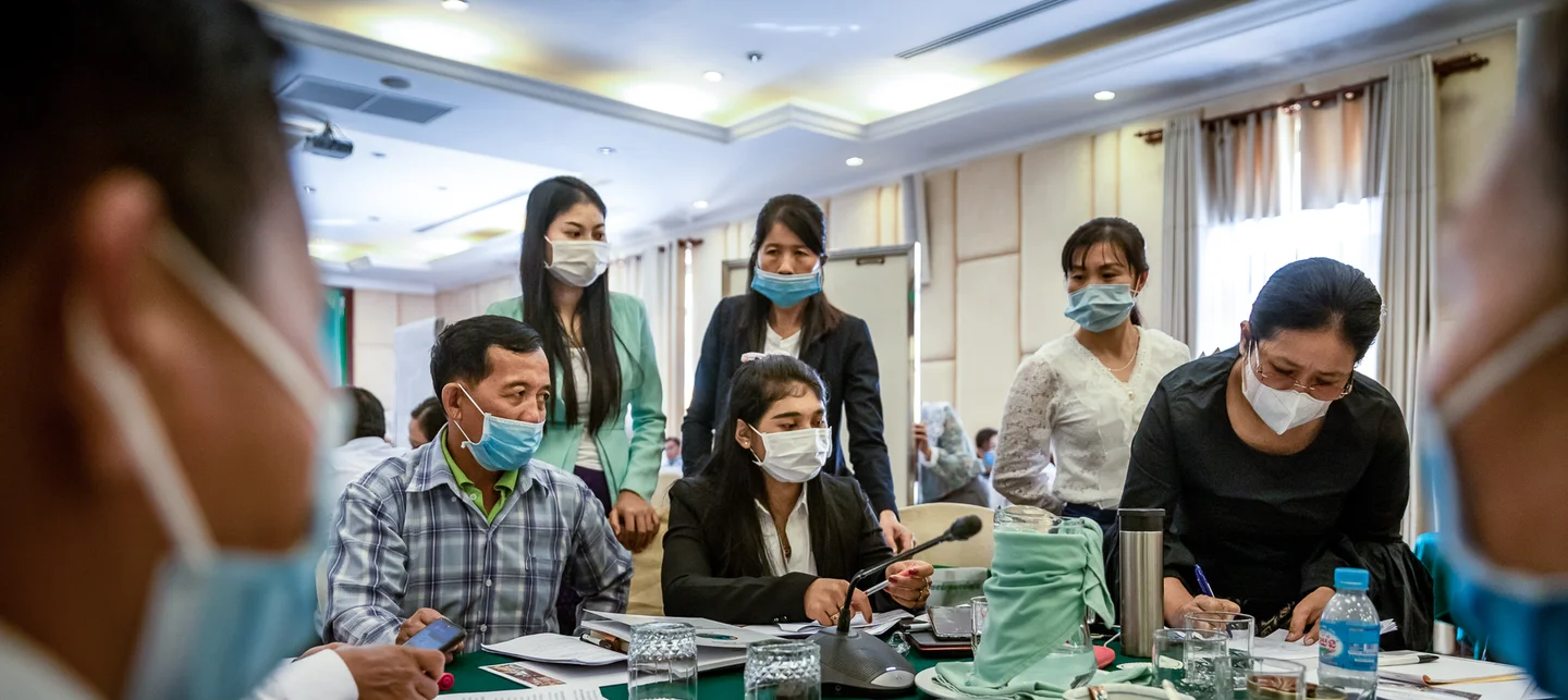 People talking at a table with face masks 